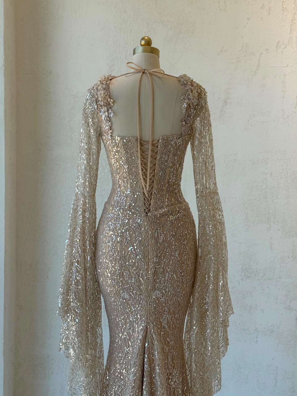 Beige mermaid gown with long flutter sleeves, embroidered bow, sequins and embroidery