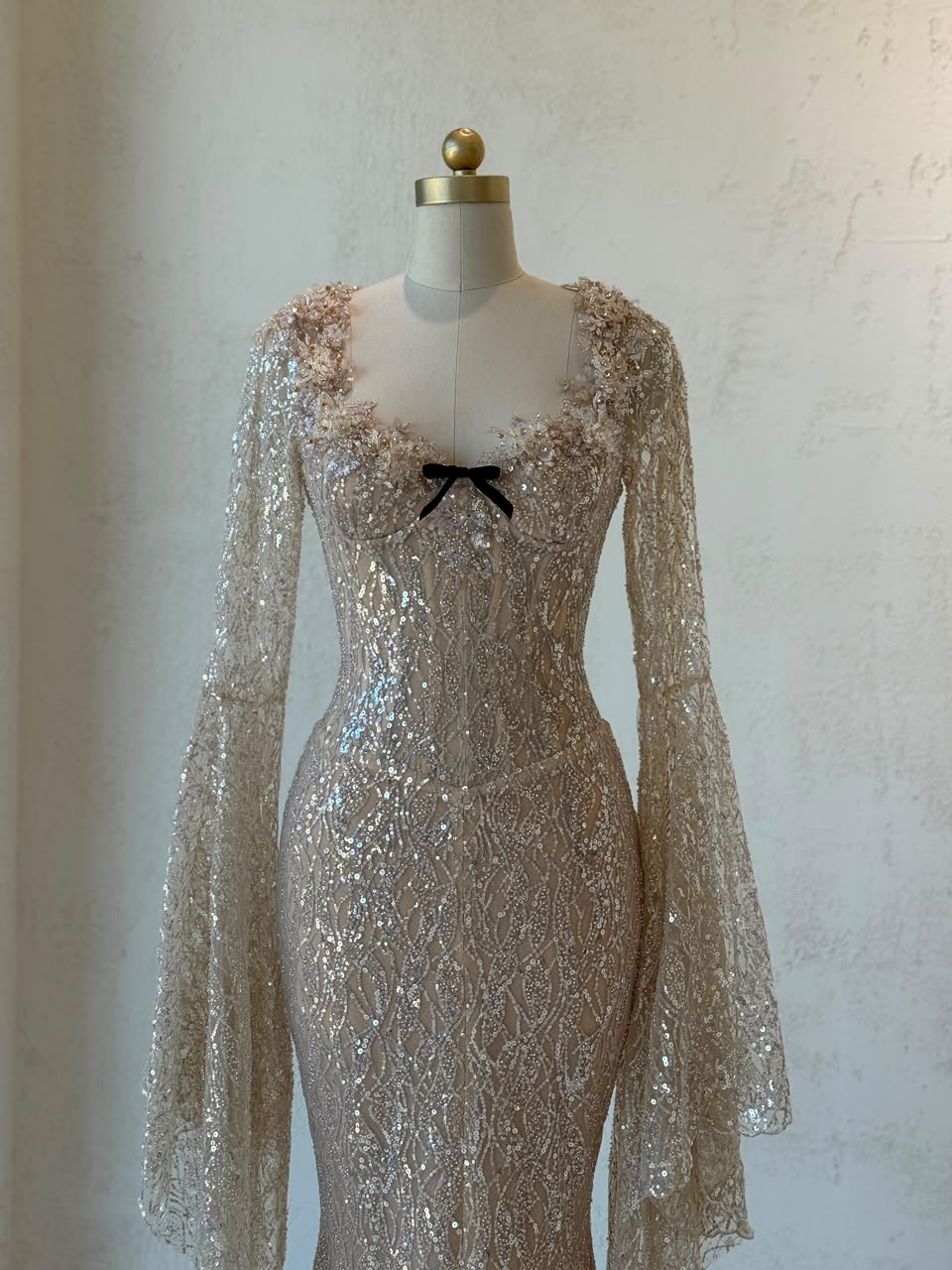 Beige mermaid gown with long flutter sleeves, embroidered bow, sequins and embroidery