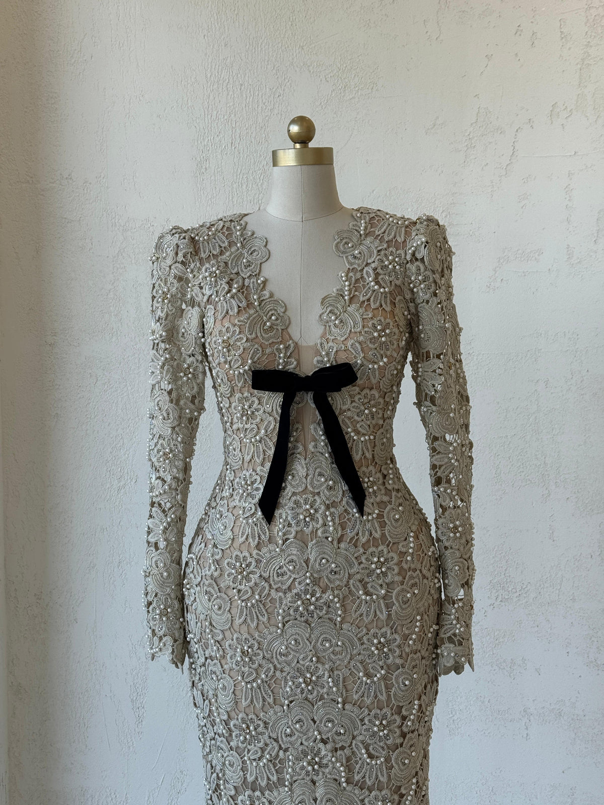 Beige mermaid gown with lace, embroidery, bow, v-neck and long sleeves