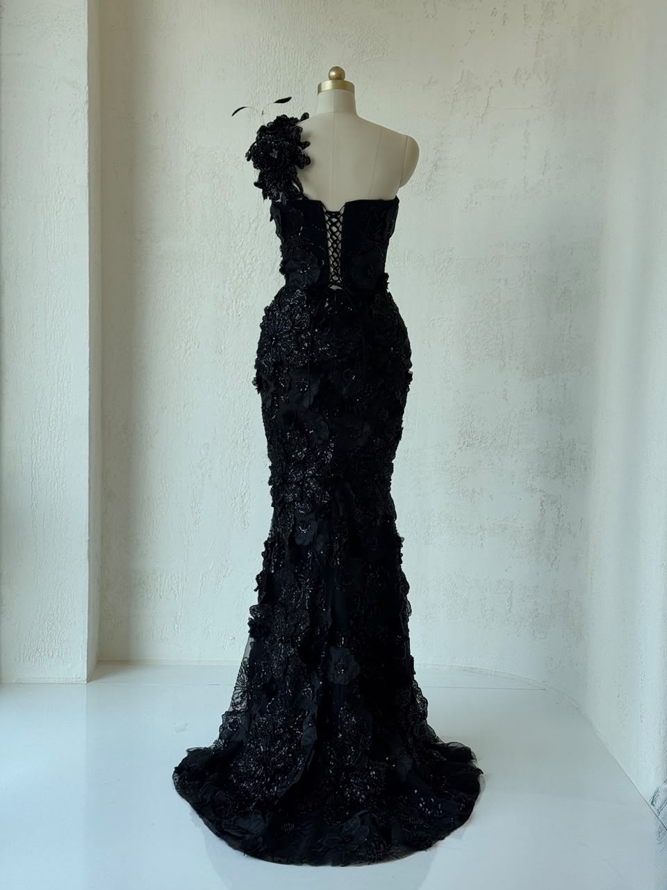 Black mermaid gown with one shoulder strap, embroidery and feathers