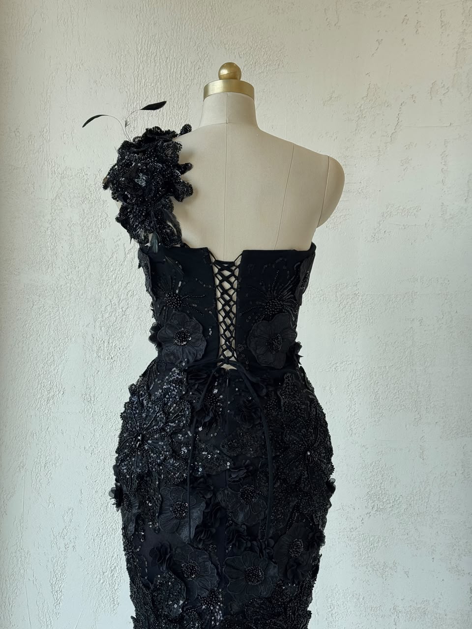 Black mermaid gown with one shoulder strap, embroidery and feathers
