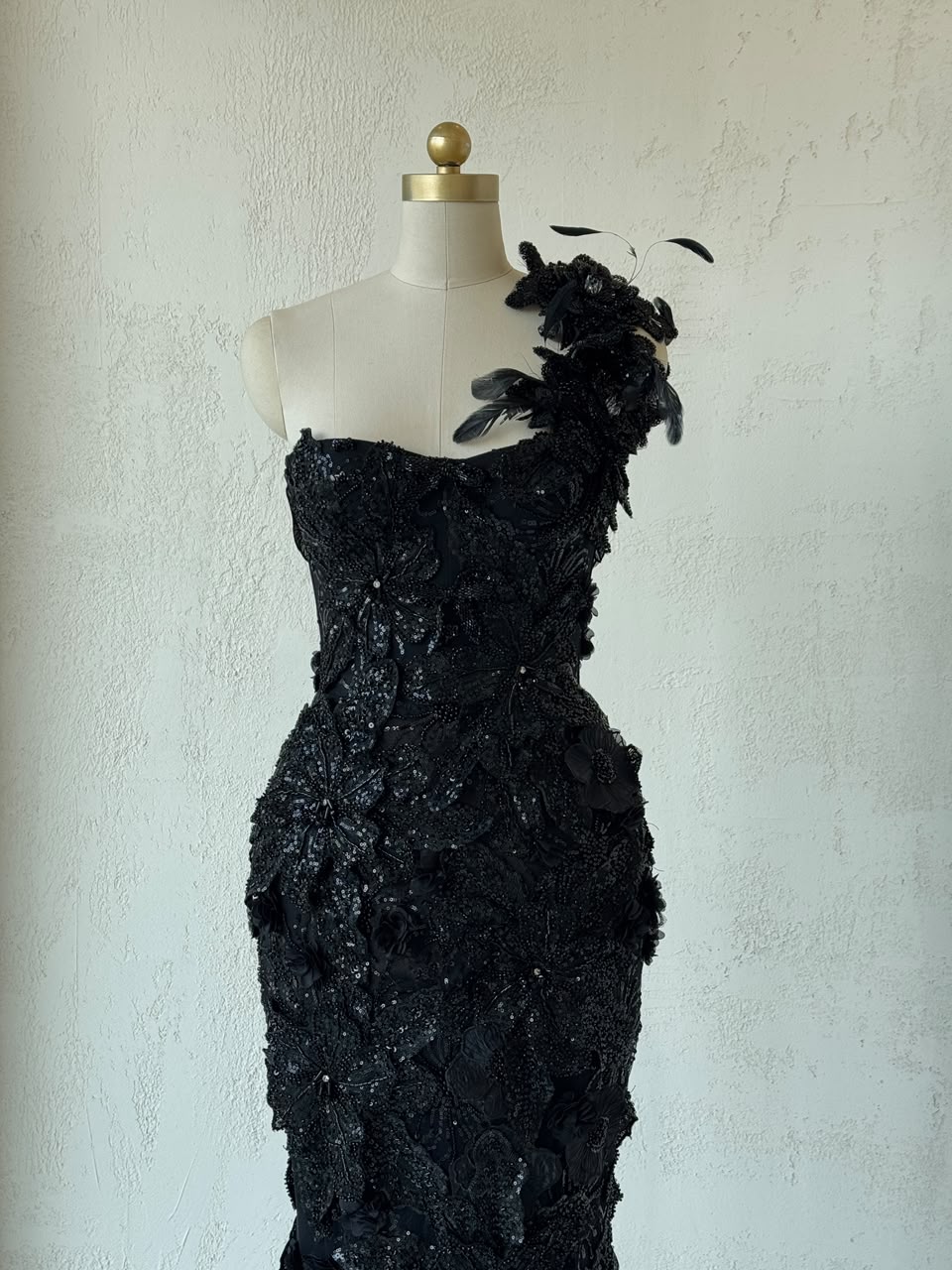 Black mermaid gown with one shoulder strap, embroidery and feathers