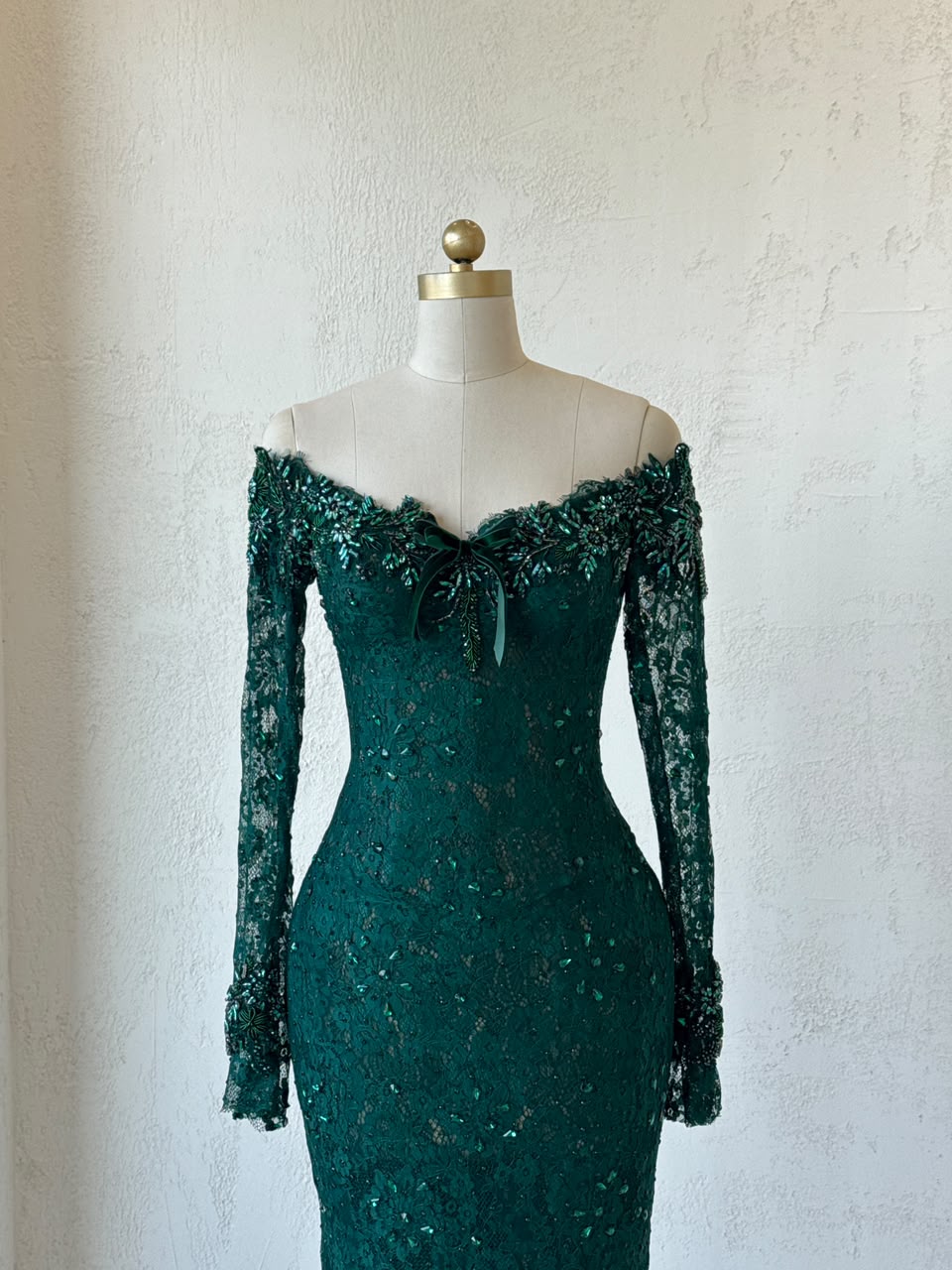Green mermaid gown with long off the shoulder sleeves, embroidery and lace