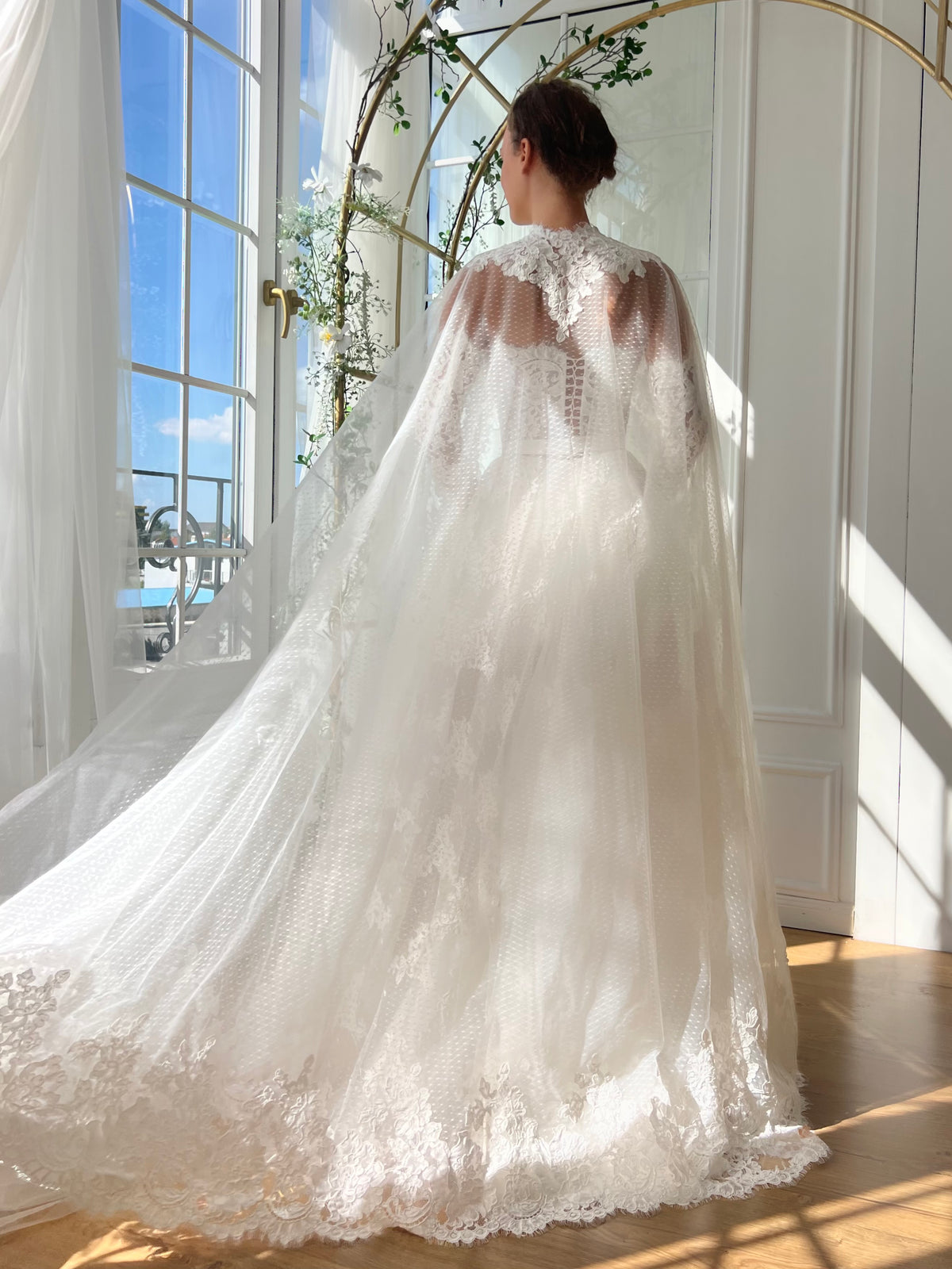White bridal A-Line gown with long off the shoulders sleeves, cape and embroidery