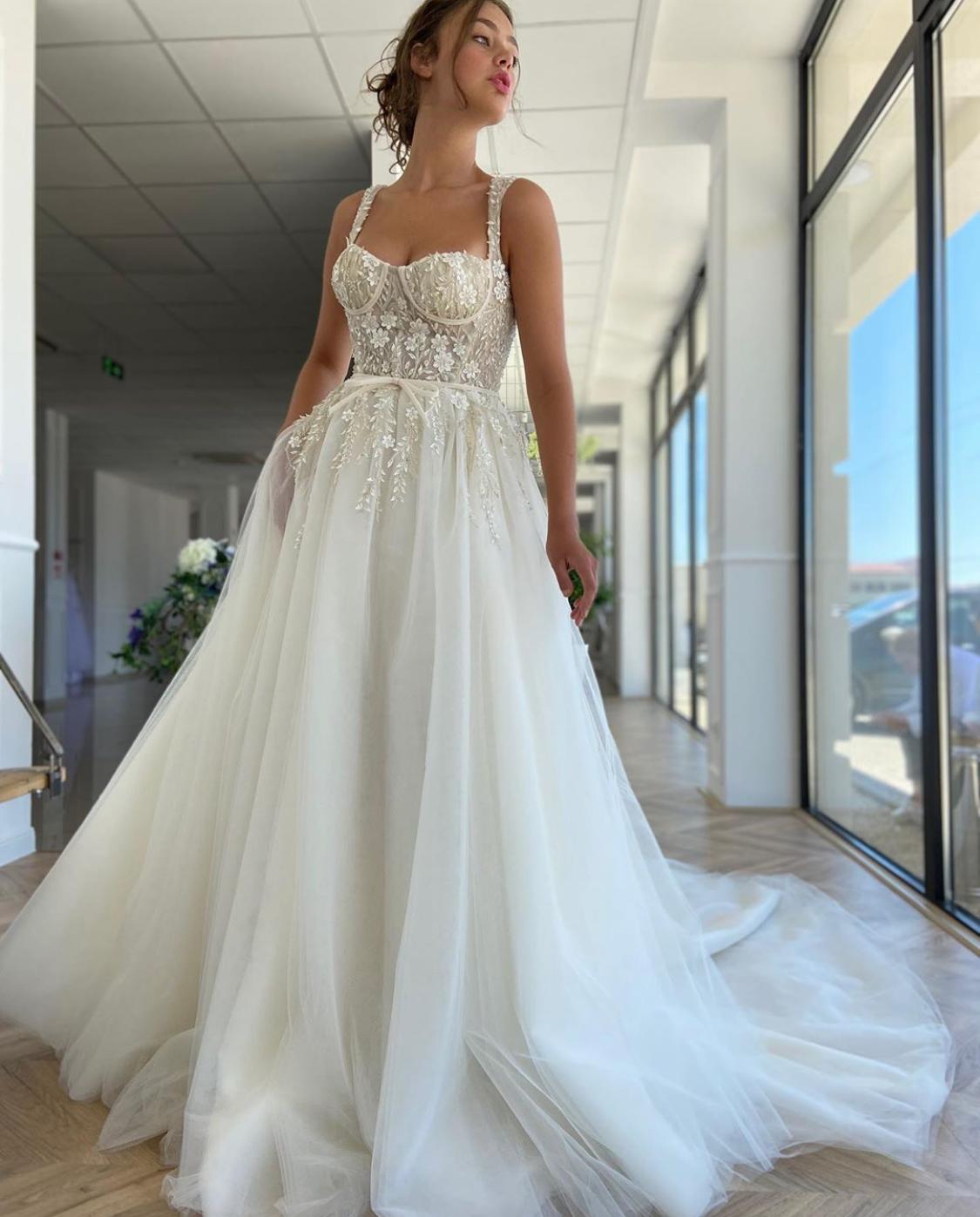 A line white bridal dress with embroidered flowers, straps and train