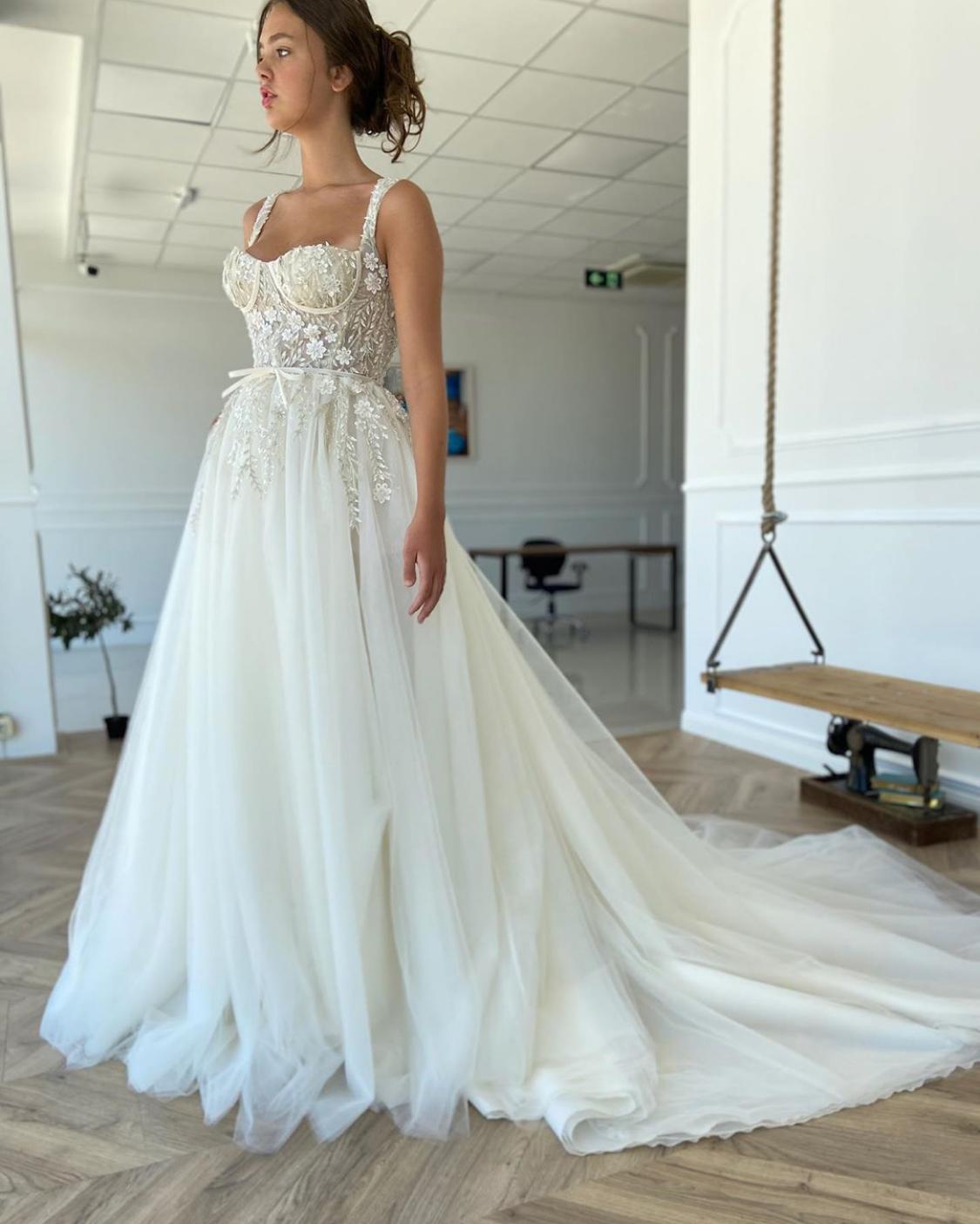 A line white bridal dress with embroidered flowers, straps and train