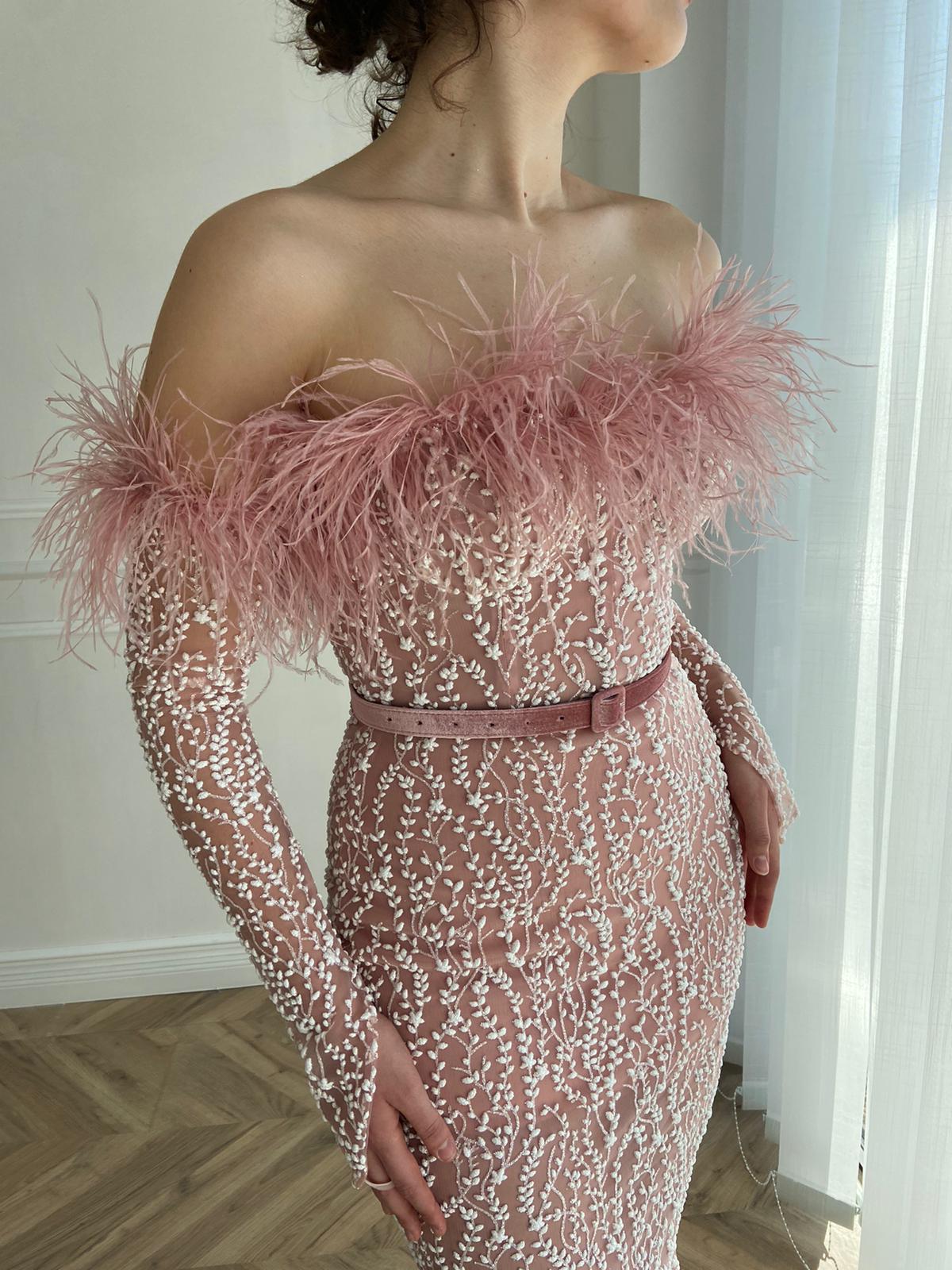 Pink mermaid dress with long off the shoulder sleeves, belt and feathers