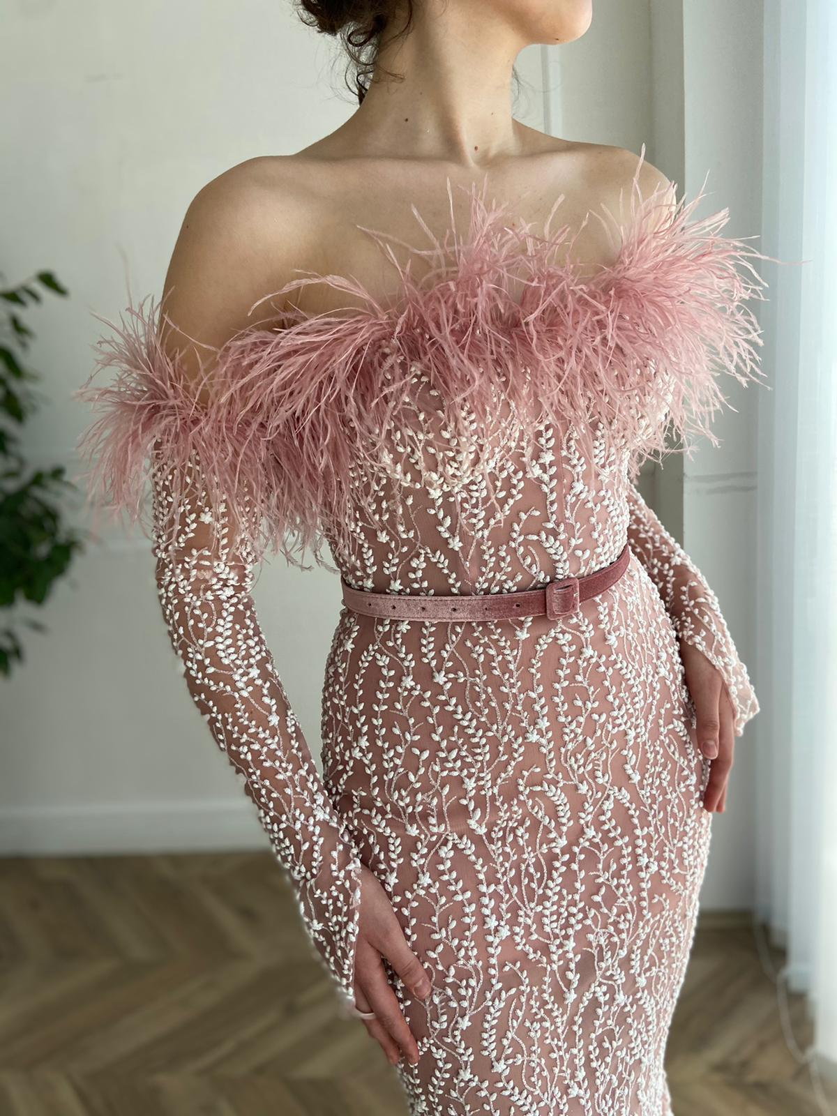 Pink mermaid dress with long off the shoulder sleeves, belt and feathers