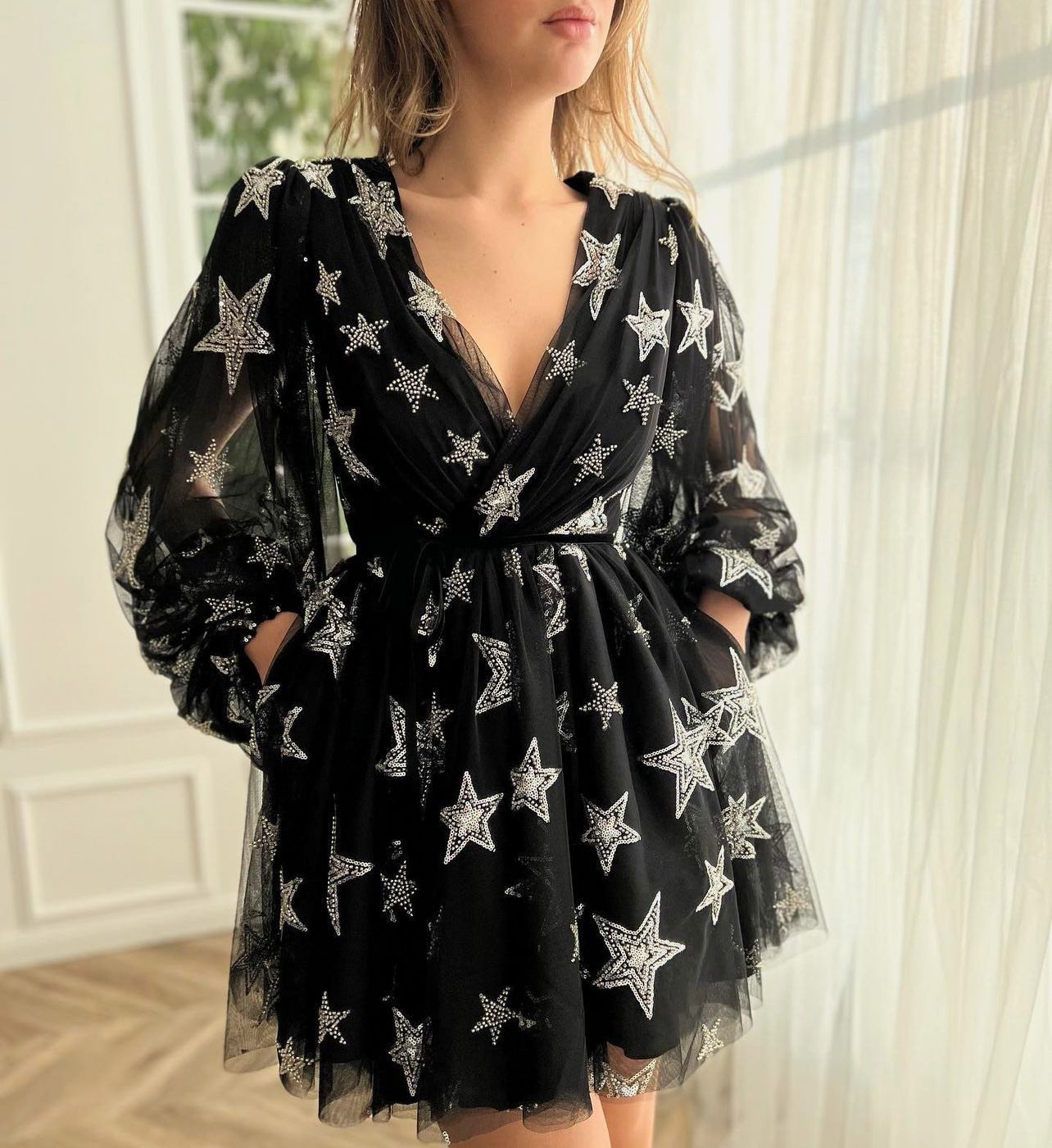 Black mini dress with v-neck, starry fabric and long sleeves