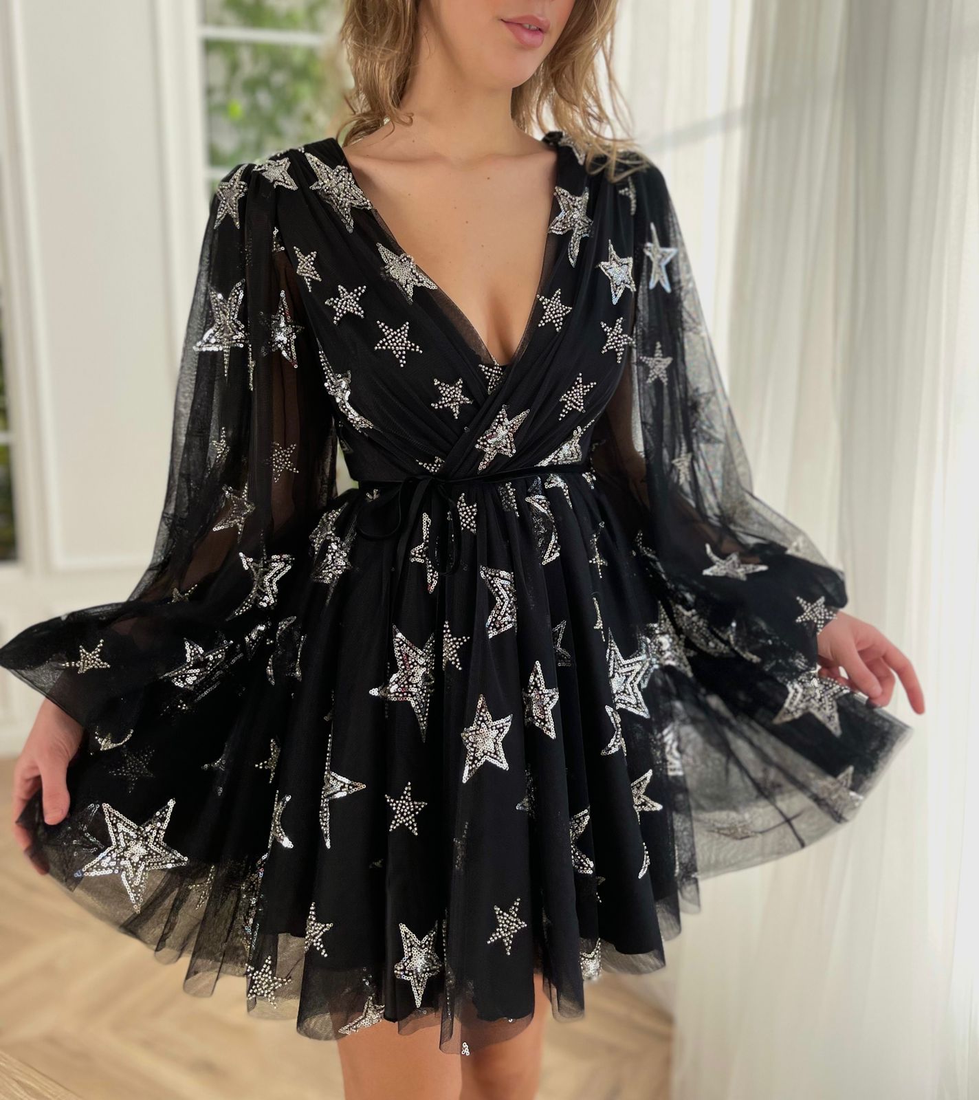 Black mini dress with v-neck, starry fabric and long sleeves