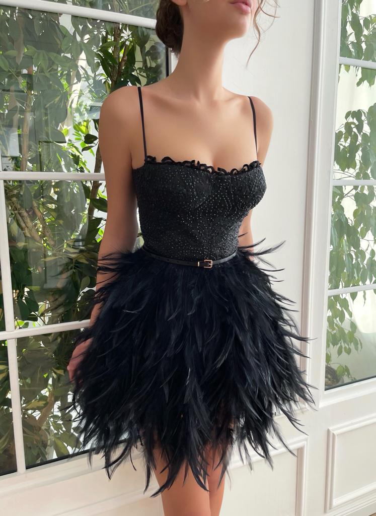 Black mini dress with spaghetti straps, belt and feathers