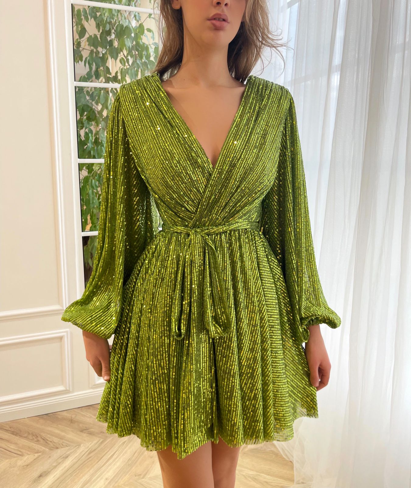 Green mini dress with sequins, v-neck and long sleeves