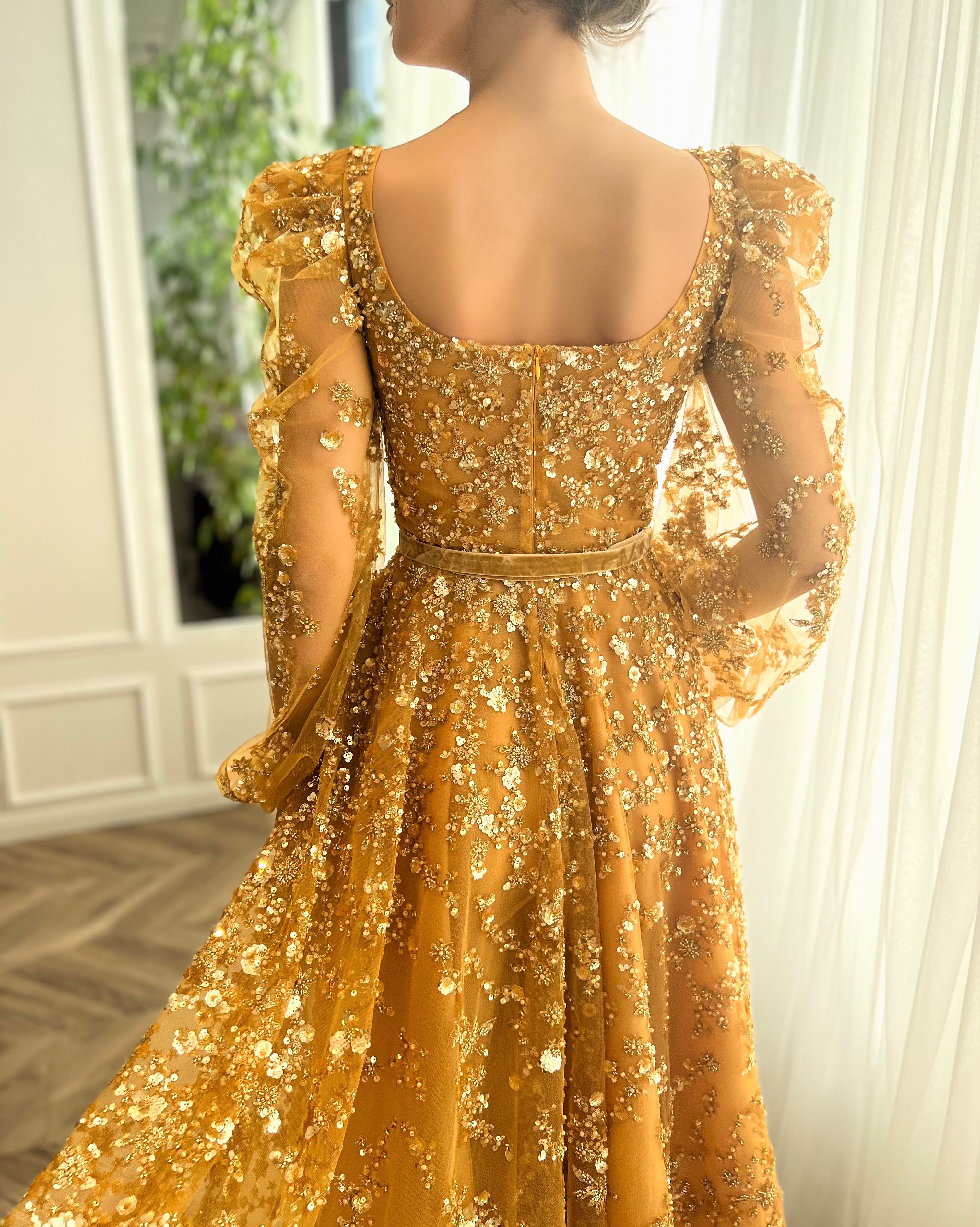 Gold A-line dress with long sleeves, belt and beading.