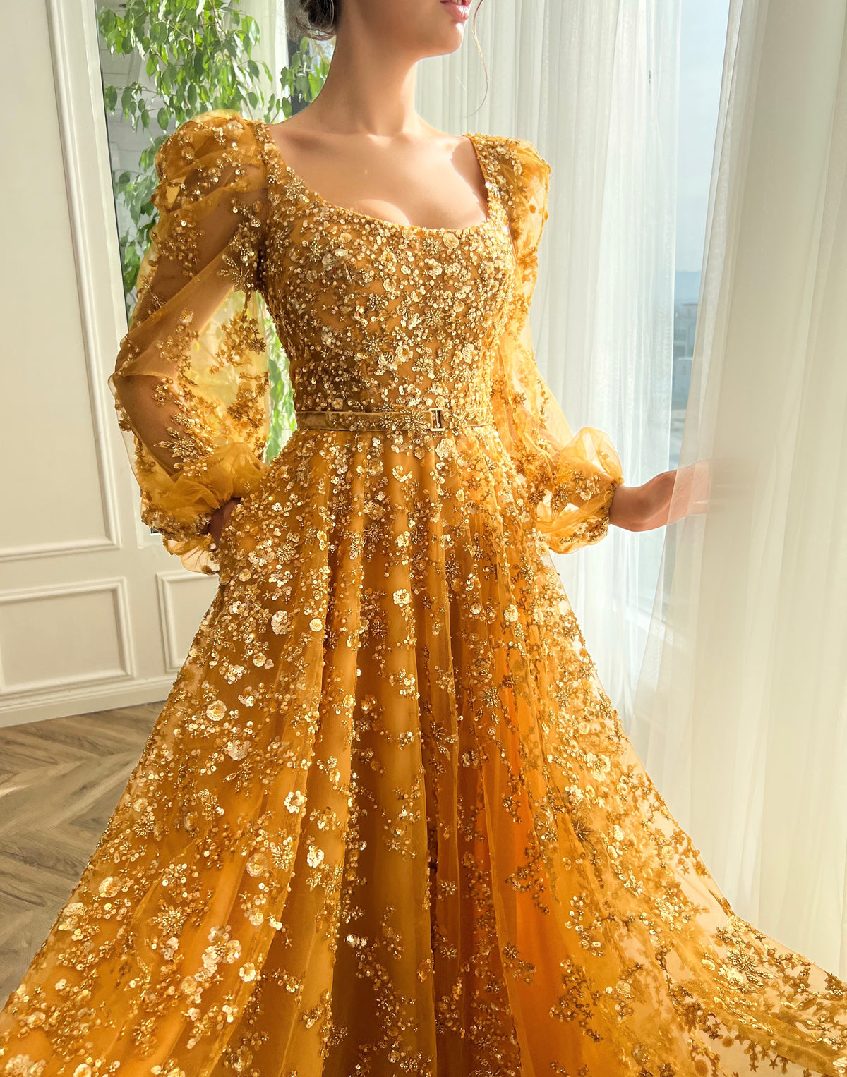 Gold A-line dress with long sleeves, belt and beading.