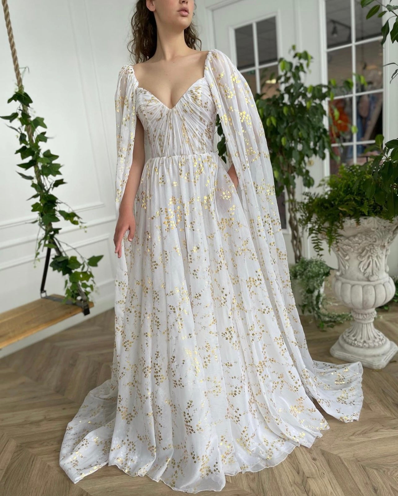 A line white bridal dress with cape, printed flowers and train