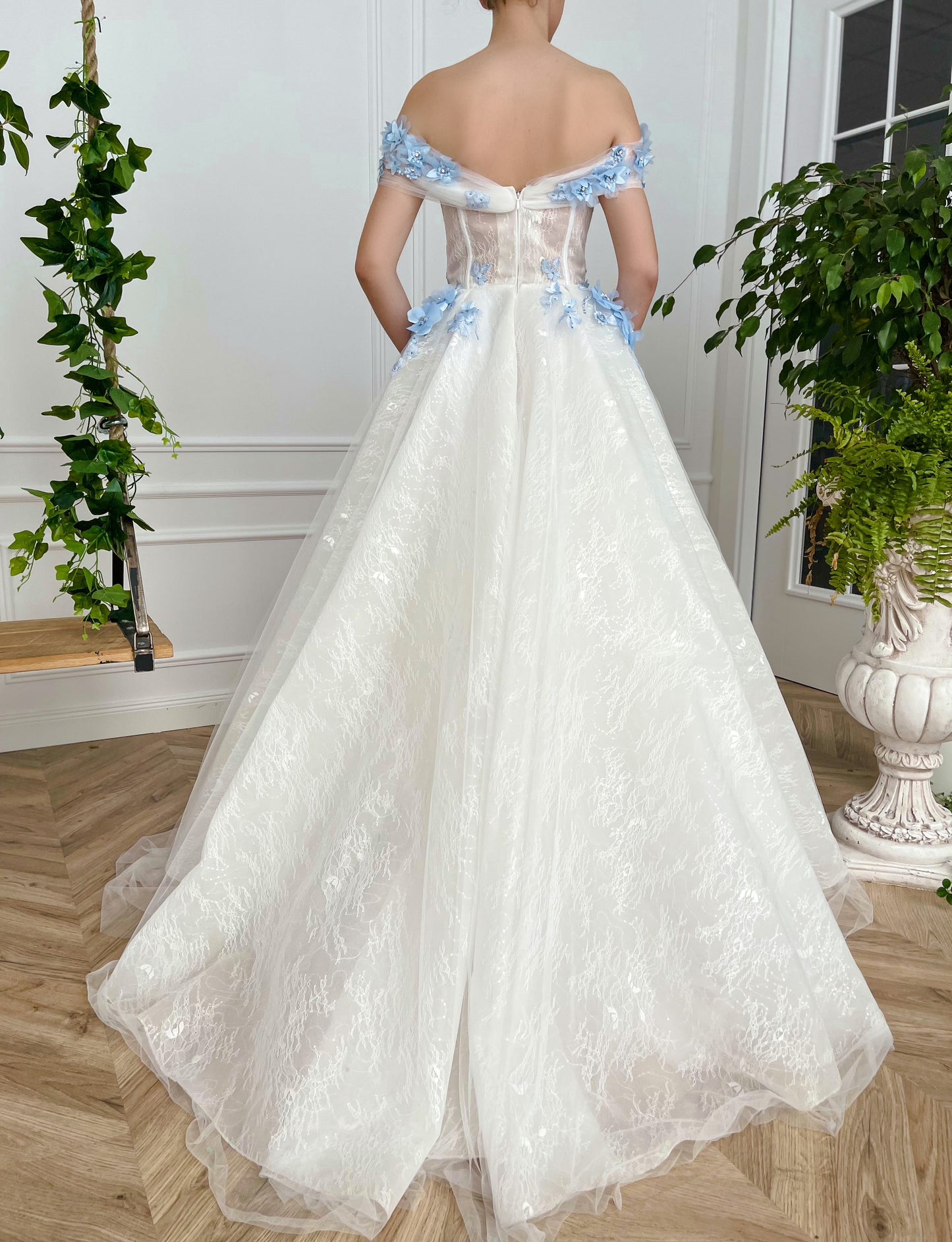 A line white bridal dress with off the shoulder sleeves and embroidered blue flowers