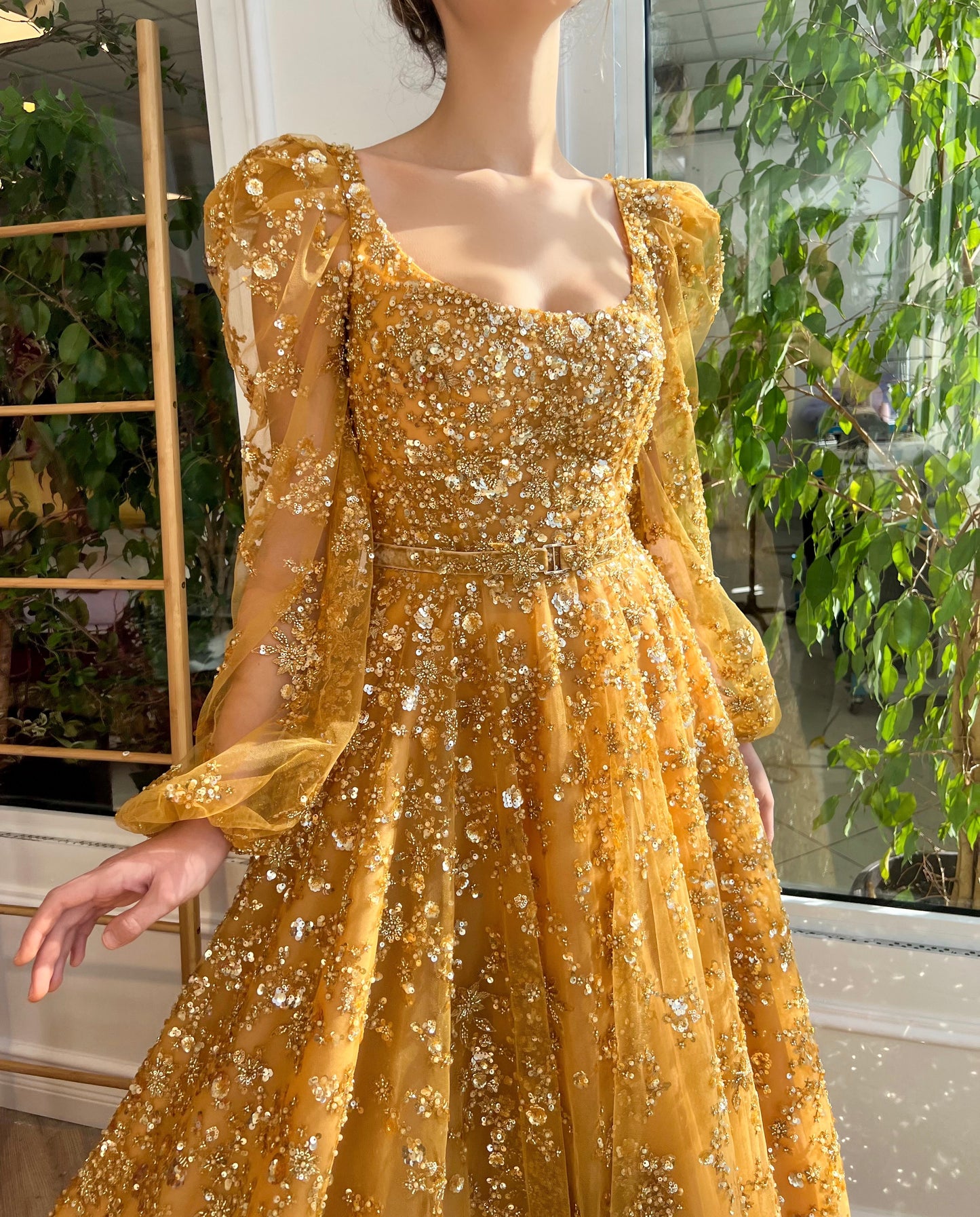 Gold A-line dress with long sleeves, belt and beading.
