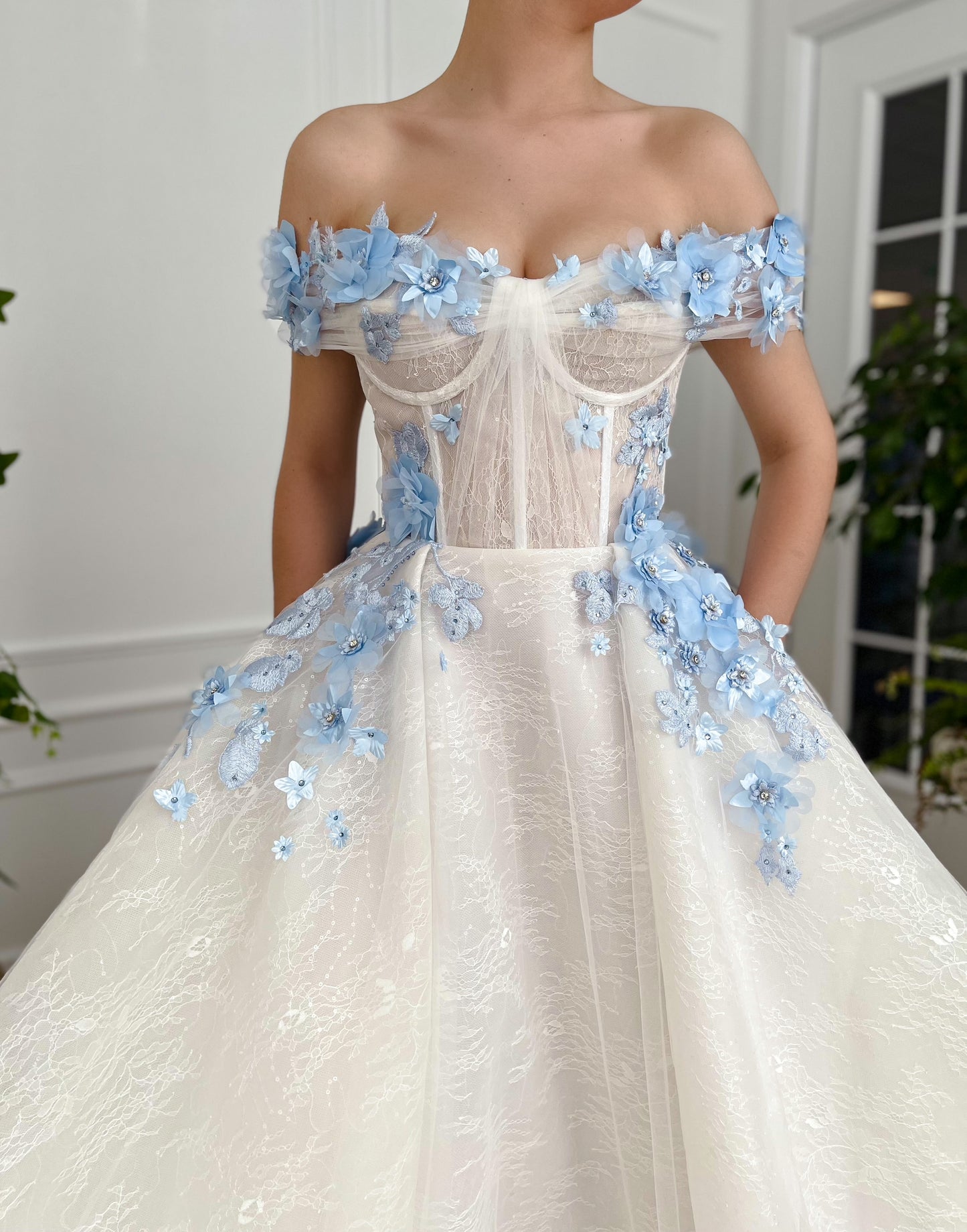 A line white bridal dress with off the shoulder sleeves and embroidered blue flowers